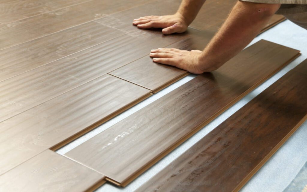 Man Installing New Laminate Wood Flooring Abstract. Man Installing New Laminate Wood Flooring Abstract.